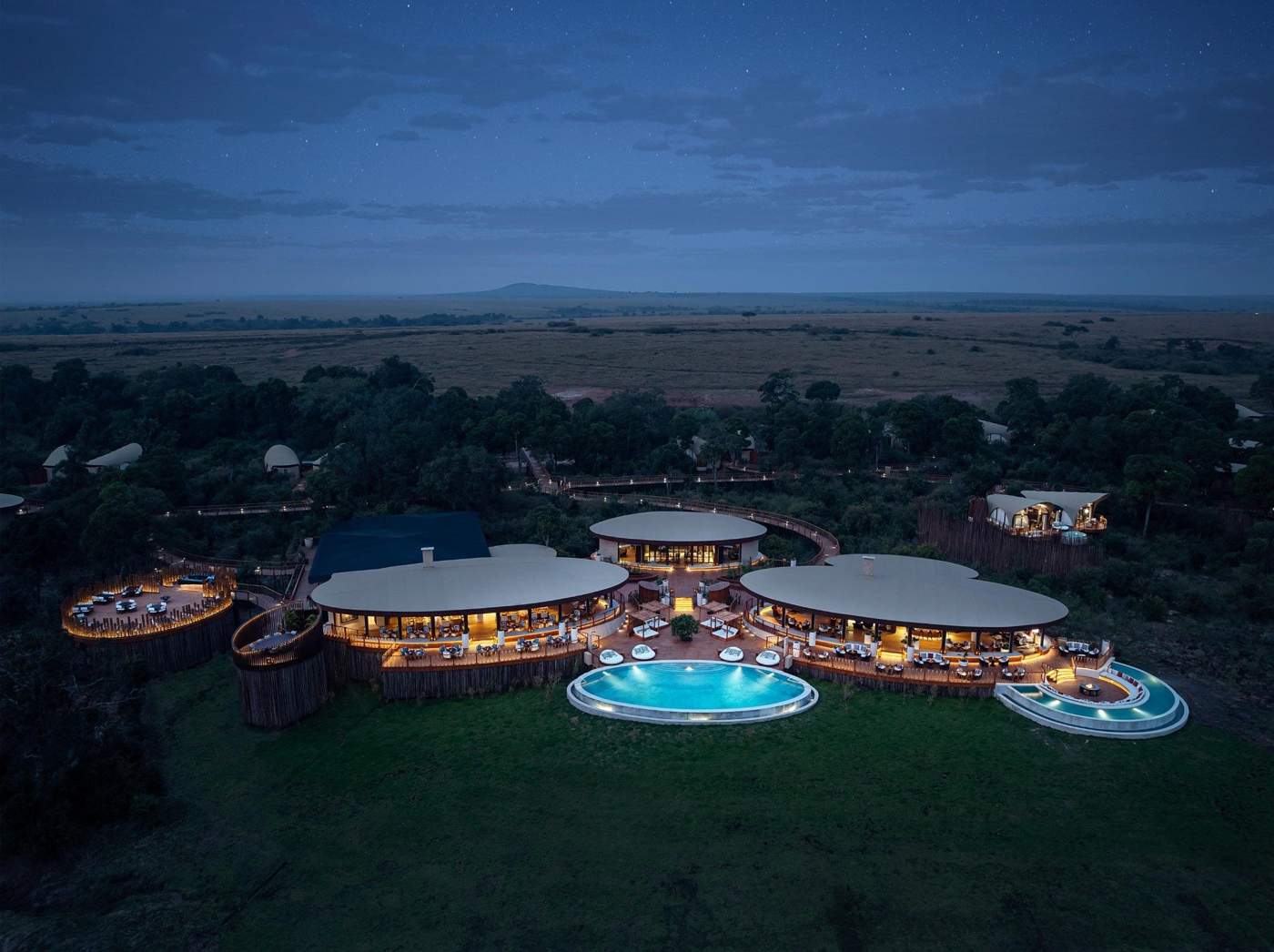 Aerial view of a luxury safari lodge at dusk overlooking the plains